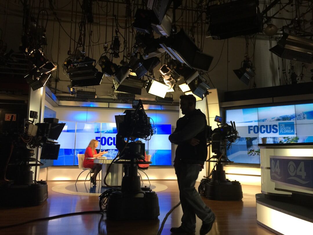 Modern TV studio set with presenter desk and large LED backdrop screen